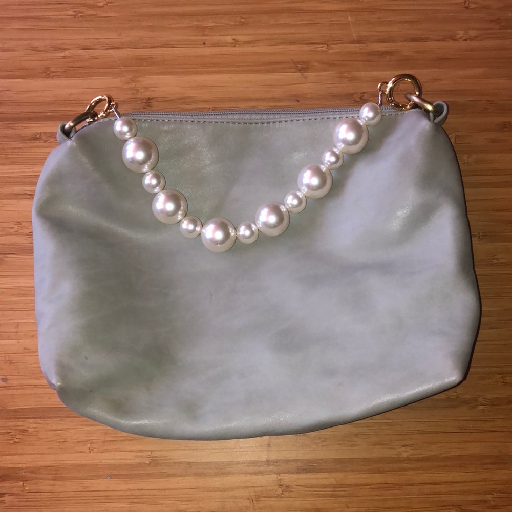 Small purse with over the shoulder pearl strap and cross body strap.